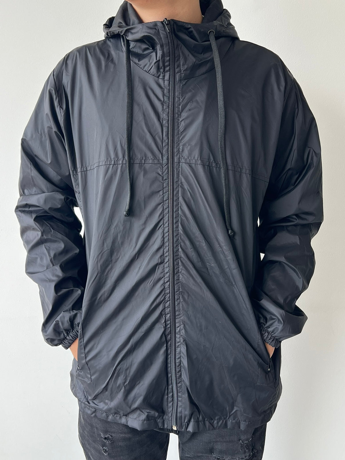 Chaqueta cortavientos SOUTH negro, vista frontal con capucha puesta