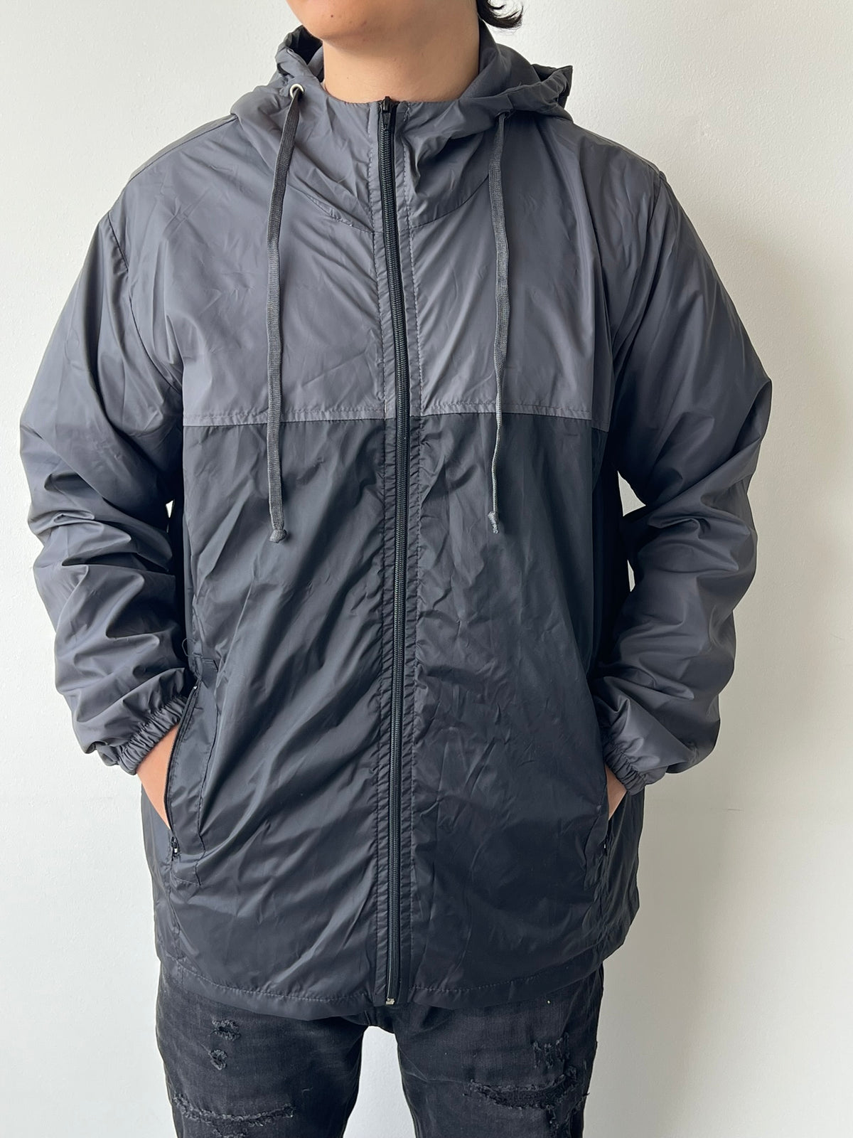 Chaqueta cortavientos SOUTH gris con negro, detalle de bolsillo y puño